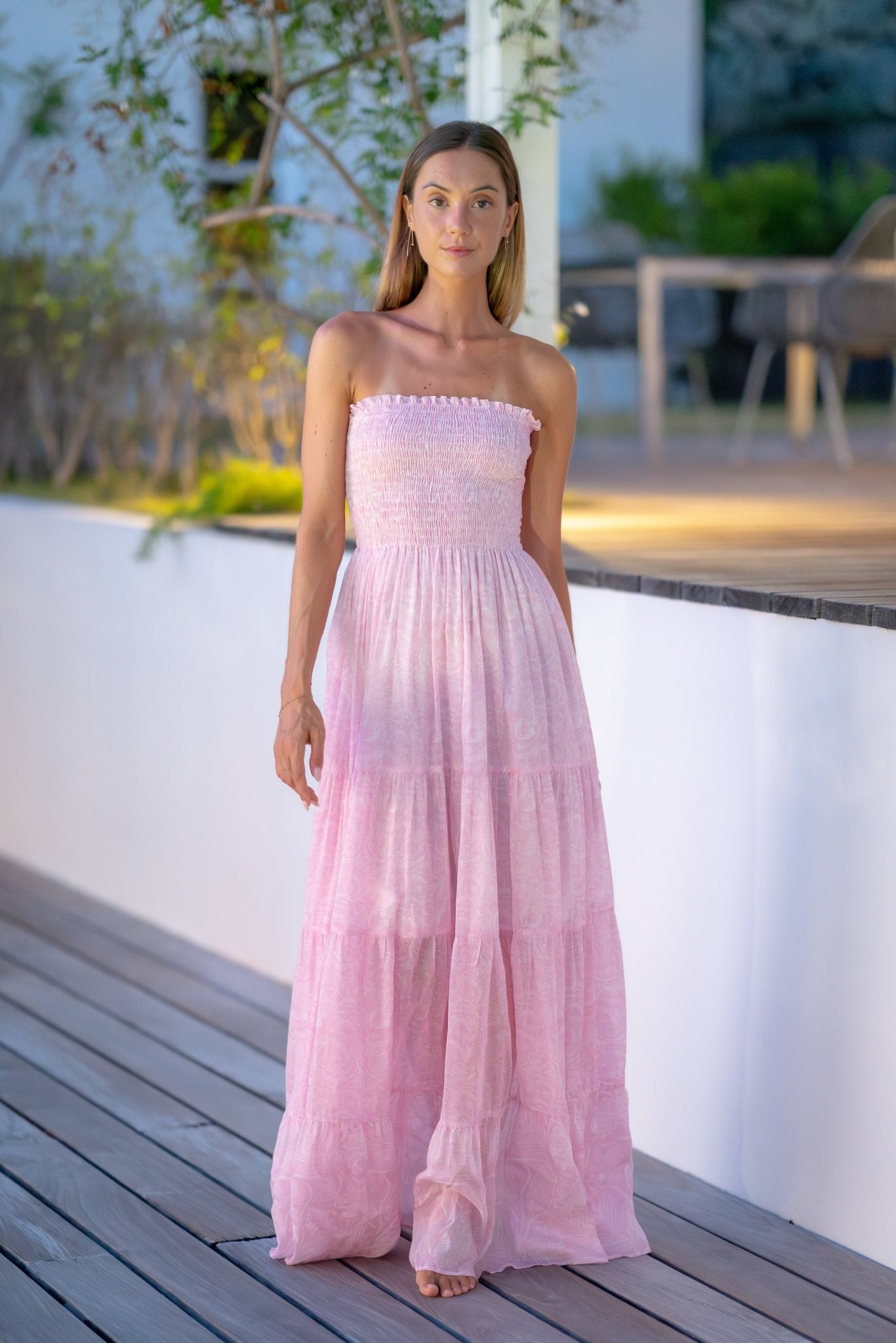 Woman in pink VM print Irene long strap dress at dusk