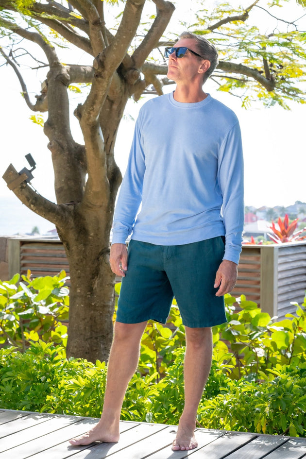 Man in forest green Valmont linen bermudas on the rocks